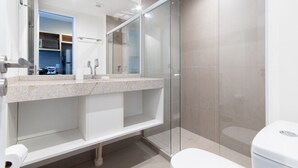 Un bagno moderno con box doccia in vetro, lavandino bianco e WC.