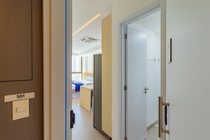 Un pasillo de hotel con el número de habitación 501 visible, una cama y un baño con ducha.