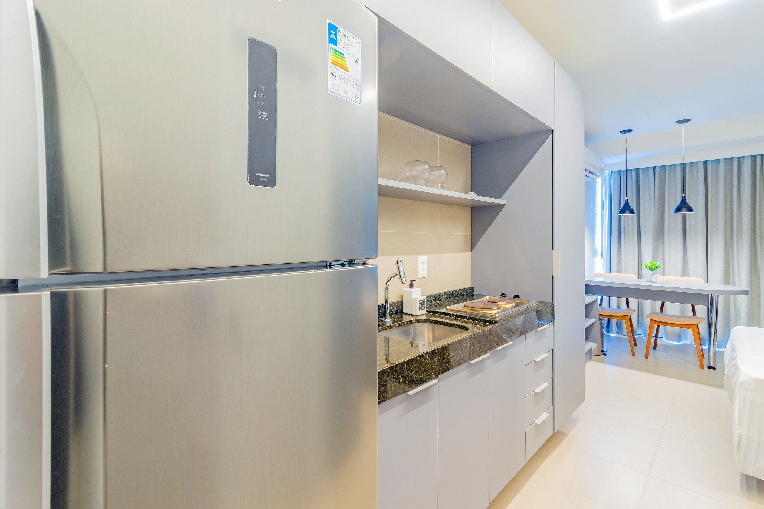 Una cocina moderna con un refrigerador de acero inoxidable, una encimera de granito y un horno empotrado.