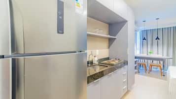 Una cocina moderna con un refrigerador de acero inoxidable, una encimera de granito y un horno empotrado.