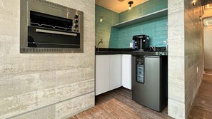 A compact kitchen with a built-in oven, a coffee machine, and a refrigerator. - Rooftop.470 Recife by Carpediem (Recife)