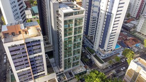 Un edificio alto con varios pisos, amplias ventanas y un estacionamiento subterráneo.