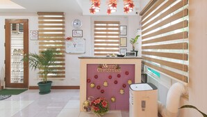 A reception area with a 'Merry Christmas' sign, a clock, and a 'No Smoking' sign. - Catlea Inn (Pasay)