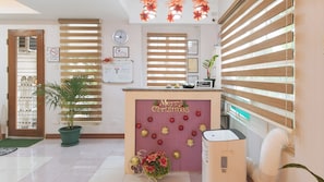 A reception area with a 'Merry Christmas' sign, a clock, and a 'No Smoking' sign. - Catlea Inn (Pasay)
