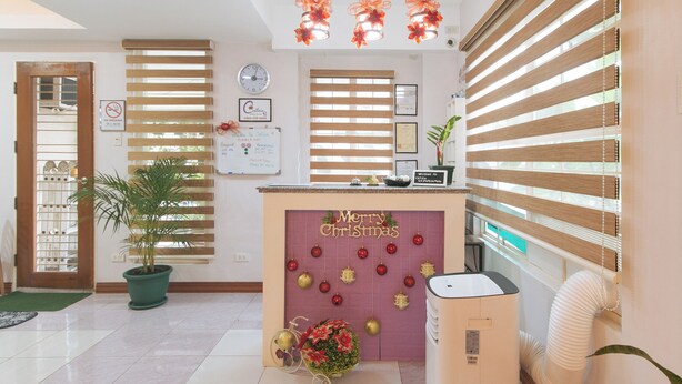 A reception area with a 'Merry Christmas' sign, a clock, and a 'No Smoking' sign. - Catlea Inn (Pasay)