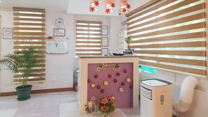 A reception area with a 'Merry Christmas' sign, a clock, and a 'No Smoking' sign. - Catlea Inn (Pasay)