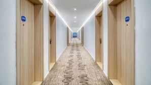 A long, narrow hotel corridor with wooden doors marked with room numbers. - elan hotel(Wulinmen Subway Station Hangzhou Xihu) (Hangzhou)