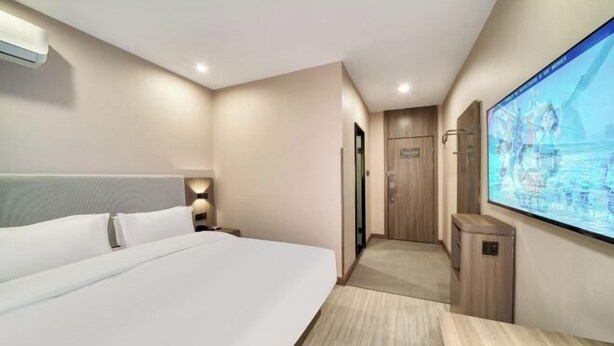 A hotel room with a large bed, a TV mounted on the wall, and a wooden desk. - elan hotel(Wulinmen Subway Station Hangzhou Xihu) (Hangzhou)