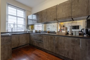 A modern kitchen with a large island, a window, and a microwave.