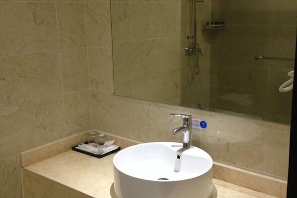A bathroom with a white sink, a mirror, and a shower. - Bamin Hotel (Lai'an)