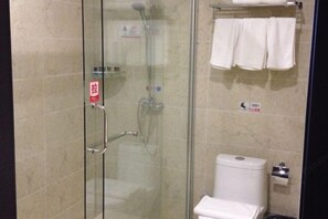 A glass-enclosed shower stall with a handrail, a toilet with a paper towel dispenser, and a towel rack with towels. - Bamin Hotel (Lai'an)