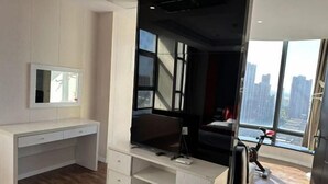 Ein modernes Zimmer mit großem Fenster, Flachbildfernseher, Schreibtisch und Laufband.