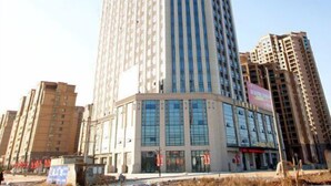 Ein Hochhaus-Hotel mit auffälliger vertikaler Beschilderung, mehreren Etagen und modernem architektonischem Design.