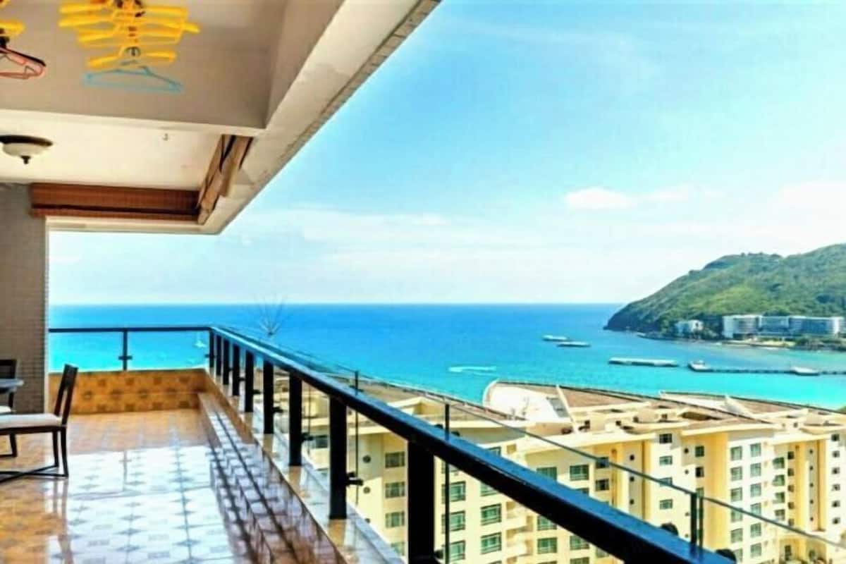 Een balkon met uitzicht op zee en gebouwen.