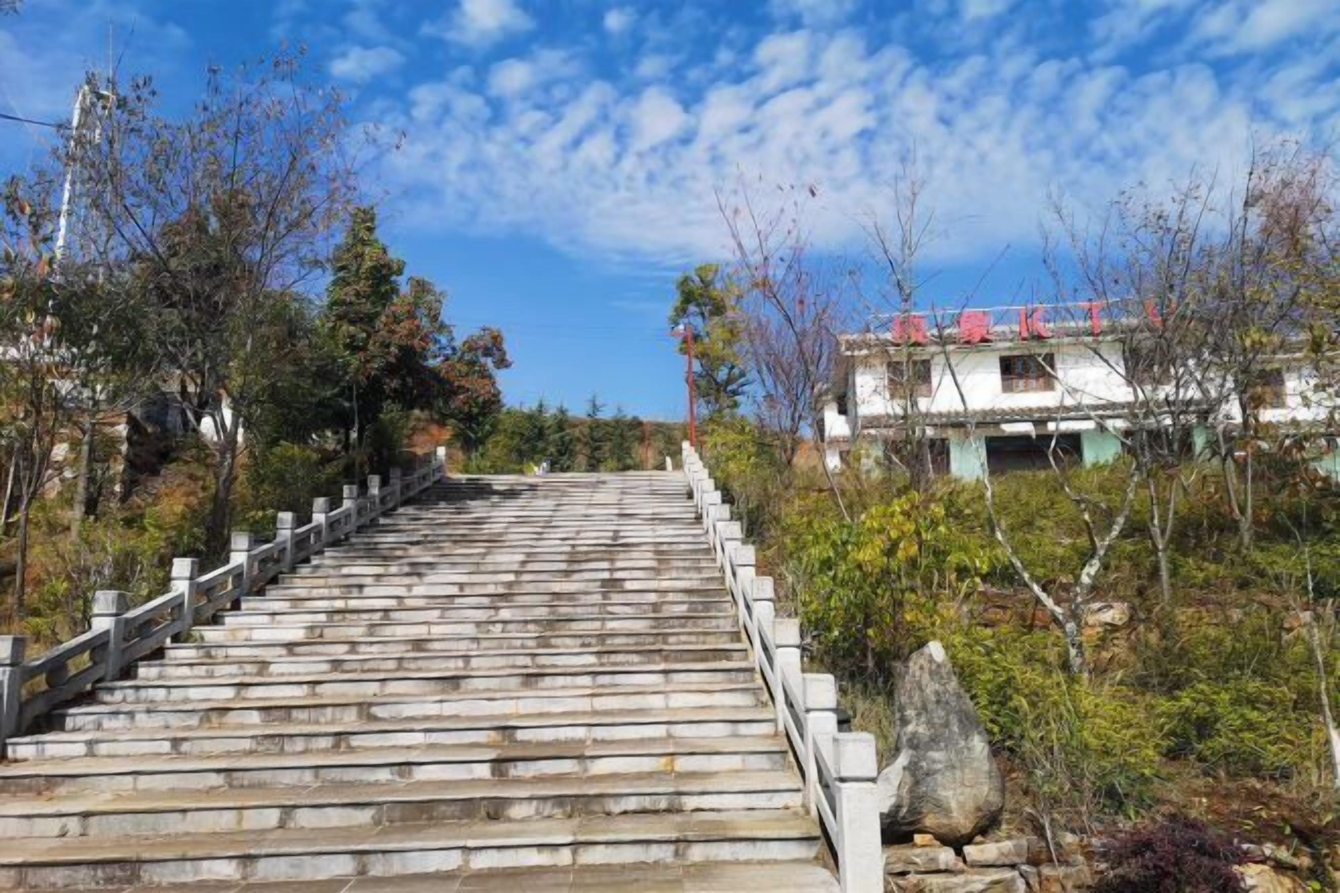 A set of stone steps leading up a hill with a building in the background.
