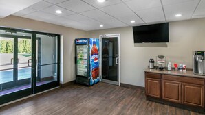 A hotel lobby with a Pepsi refrigerator, a coffee station, and a glass door leading outside. - Knights Inn Bristol (Bristol)