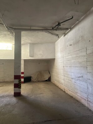 Exposed pipes run along the ceiling, while a striped safety sign and concrete floor add to the room's industrial feel.