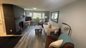 A living room with a fireplace, a television, a sofa, and a coffee table.