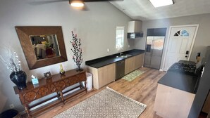 A modern kitchen with wooden cabinets, a built-in dishwasher, a stove, and a large mirror above the counter. - Huge house for large groups! Basketball court, arcade, putting green.4 bathroom (Machesney Park)