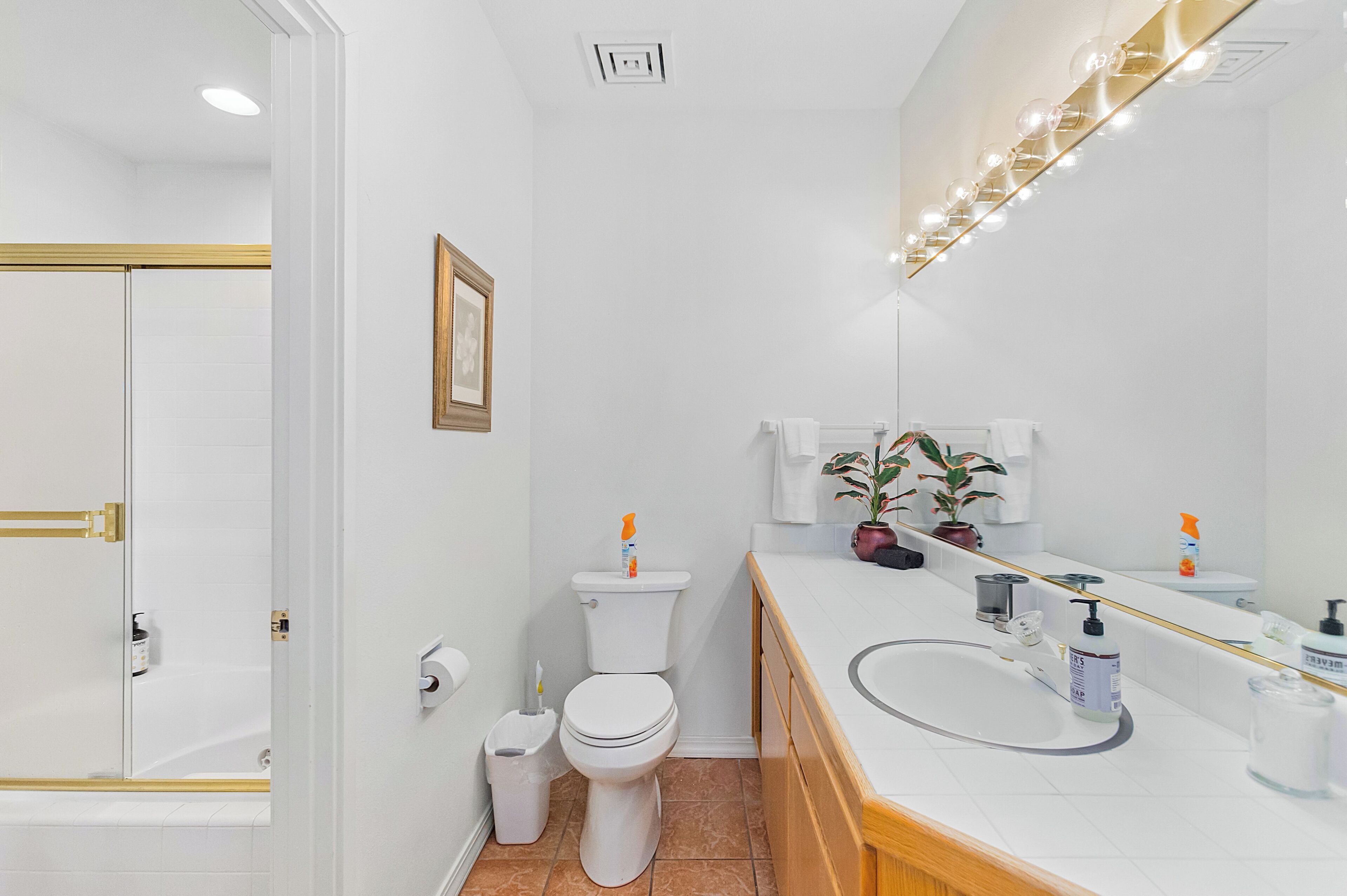 A modern bathroom with a toilet, sink, and mirror.