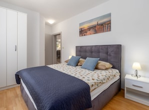 A bedroom with a bed, a nightstand, a painting, and a wardrobe. - Villa Sabina - Breg Ivanovci (Labin)