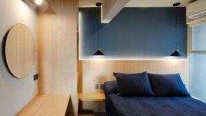 A modern bedroom with a bed, bedside tables, and pendant lights. - La Hospedería León (León)