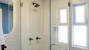 A modern bathroom with a glass-enclosed shower, a white sink, and a toilet. - La Hospedería León (León)