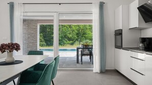 Een moderne keuken met witte kasten, een zwarte afzuigkap en een koffiezetapparaat.