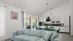 Een moderne woonkamer met een bank en een eethoek.