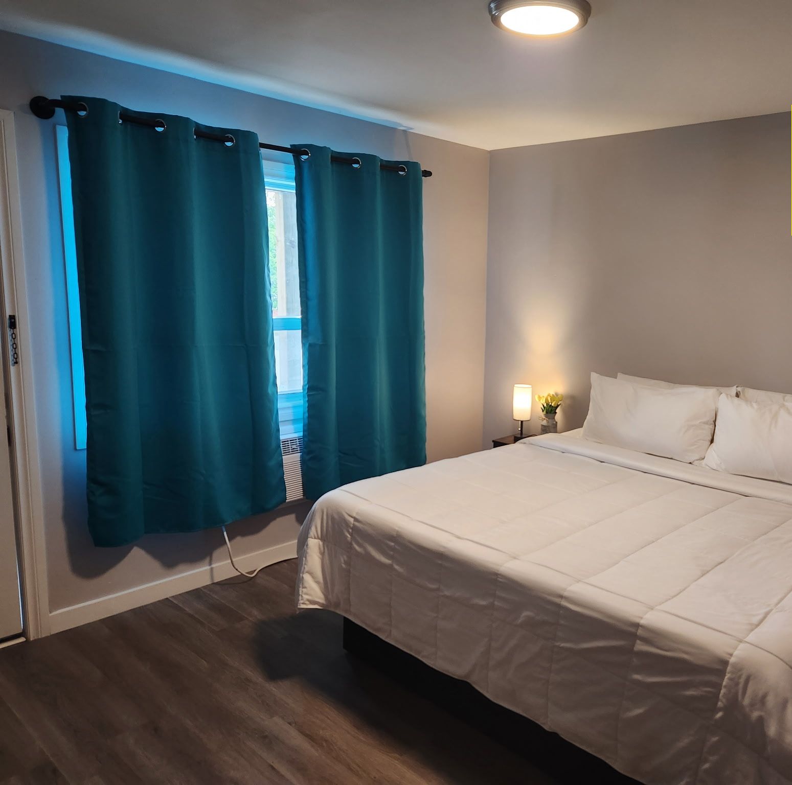 A bedroom with a bed, curtains, a nightstand, and a wall-mounted light. A note indicates no TV or WiFi.