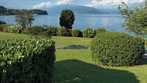 A well-maintained garden with a clear view of a lake and distant mountains. - Stupenda Vista Lago, Appartamento con Piscina (Solarolo)