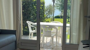 A room with a sliding glass door leading to an outdoor patio with a table and chairs. - Stupenda Vista Lago, Appartamento con Piscina (Solarolo)