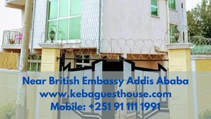 Un edificio de varios pisos con entrada protegida por una reja, cerca de la embajada británica.