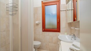 A bathroom with a toilet, sink, and shower. - Casa Rosella by Wonderful Italy (Olbia)