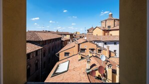 Vista di una stretta via fiancheggiata da edifici con tetti in terracotta e una chiesa imponente con una cupola.