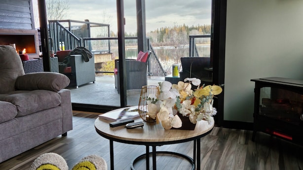 Una sala de estar moderna con un sofá, una mesa redonda de centro con un florero y una chimenea.