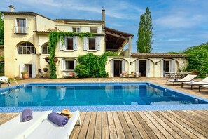 Un espace piscine avec des chaises longues et une terrasse en bois.
