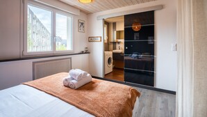 Una habitación de hotel con una cama, una ventana, una lavadora y un letrero que dice