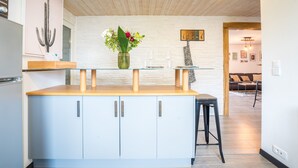 Una cocina moderna con armarios azul claro, una encimera de madera y un florero con flores.
