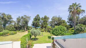 Una zona residenziale con prato verde, una panchina e diversi alberi.