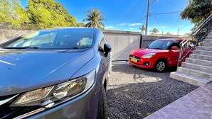 A parking area with two cars, one red and one silver, parked on gravel. - Modern apartment for rent in La Gaulette.
Suitable for couple or family. (La Gaulette)