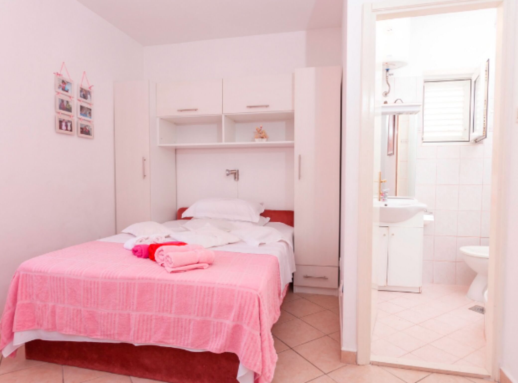 A bedroom with a bed, a wardrobe, and a bathroom visible through an open door.