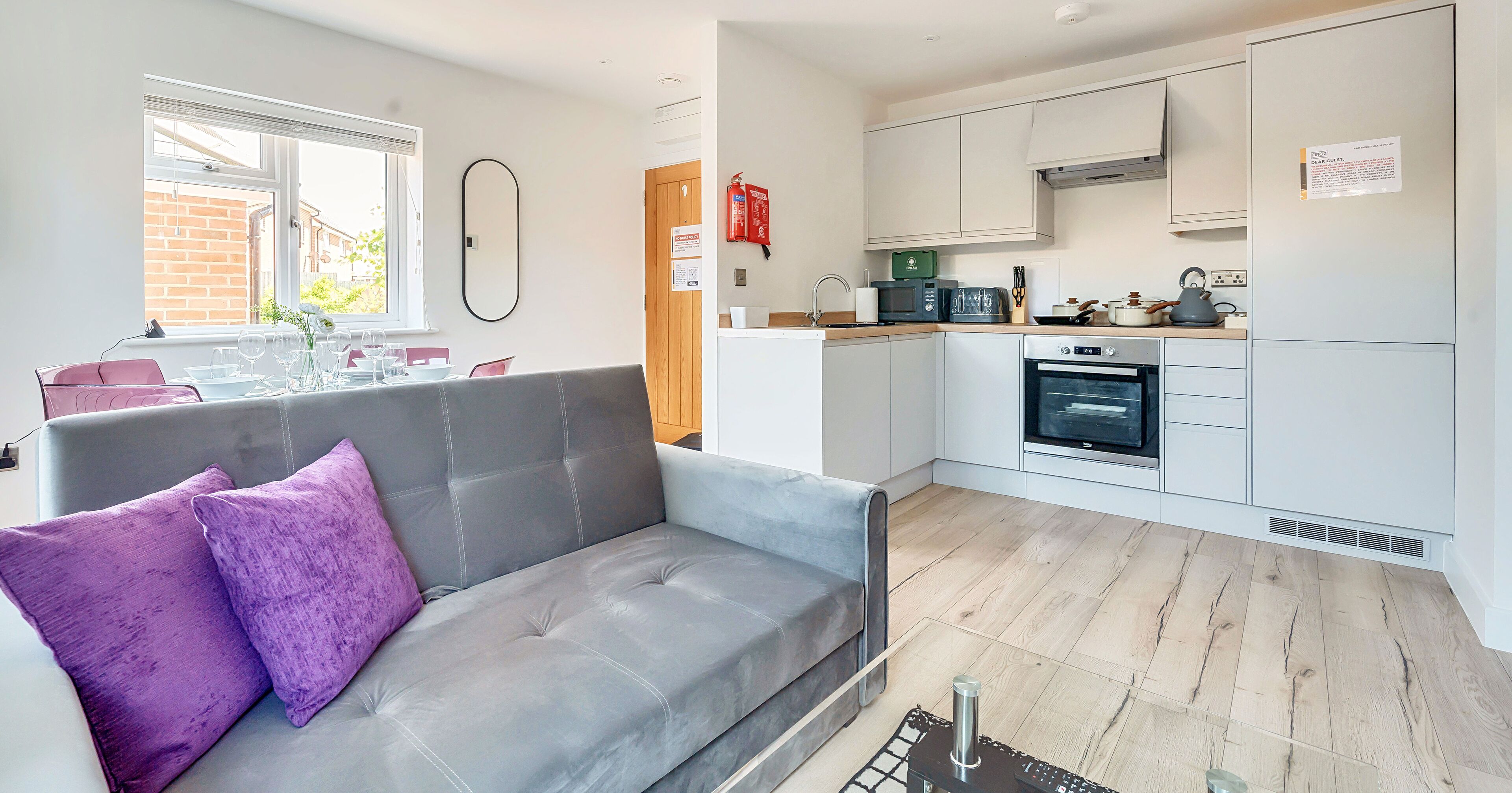 A modern kitchen with white cabinets, a microwave, and a stove.