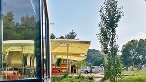 Un restaurant avec une terrasse, des parasols jaunes et une enseigne à l’effigie de Coca-Cola.