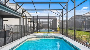Un espace piscine doté d’une partie couverte et offrant une vue dégagée sur le quartier environnant.