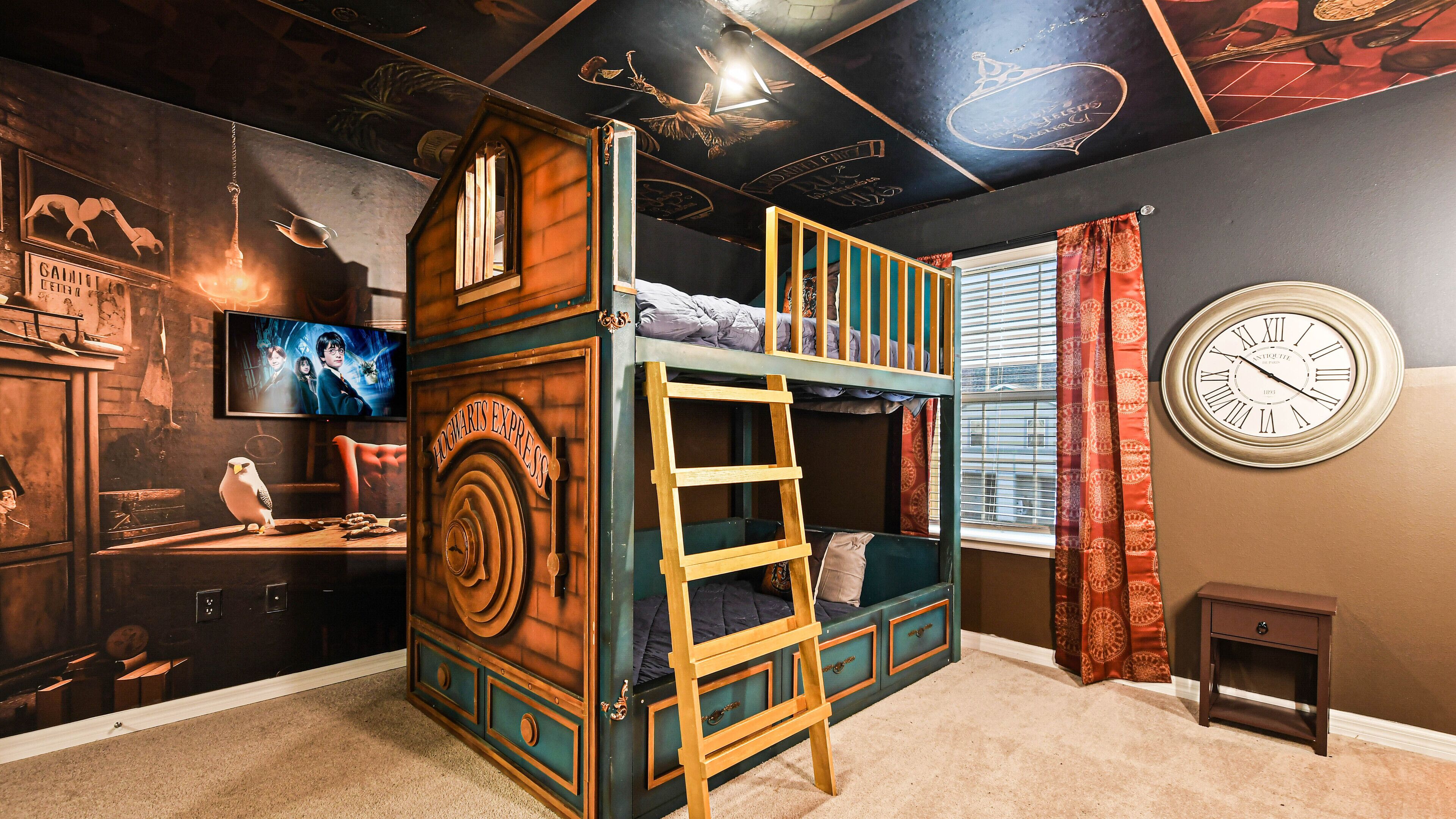 A themed room with a bunk bed, a wooden ladder, a wall clock, and a television.