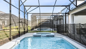 A swimming pool with a hot tub, surrounded by a covered patio area with a view of a house and garden. - Last Minute Disney! Private Pool, Hot Tub, Game Room & Themed Bedrooms. Book Now! #111505 (Orlando)