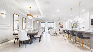 A spacious dining area with a long table, multiple chairs, and elegant chandeliers. - Last Minute Disney! Private Pool, Hot Tub, Game Room & Themed Bedrooms. Book Now! #111505 (Orlando)