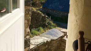Un arco de piedra que da a una vista panorámica de una playa y acantilados.