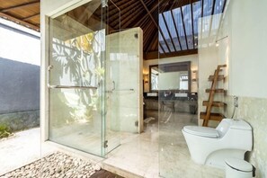 Une salle de bain moderne avec une douche à parois de verre, des toilettes blanches et une échelle en bois.